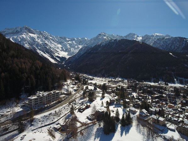 Pueblo cubierto de nieve con una montaña al fondo, que presenta una combinación de edificios residenciales y comerciales.