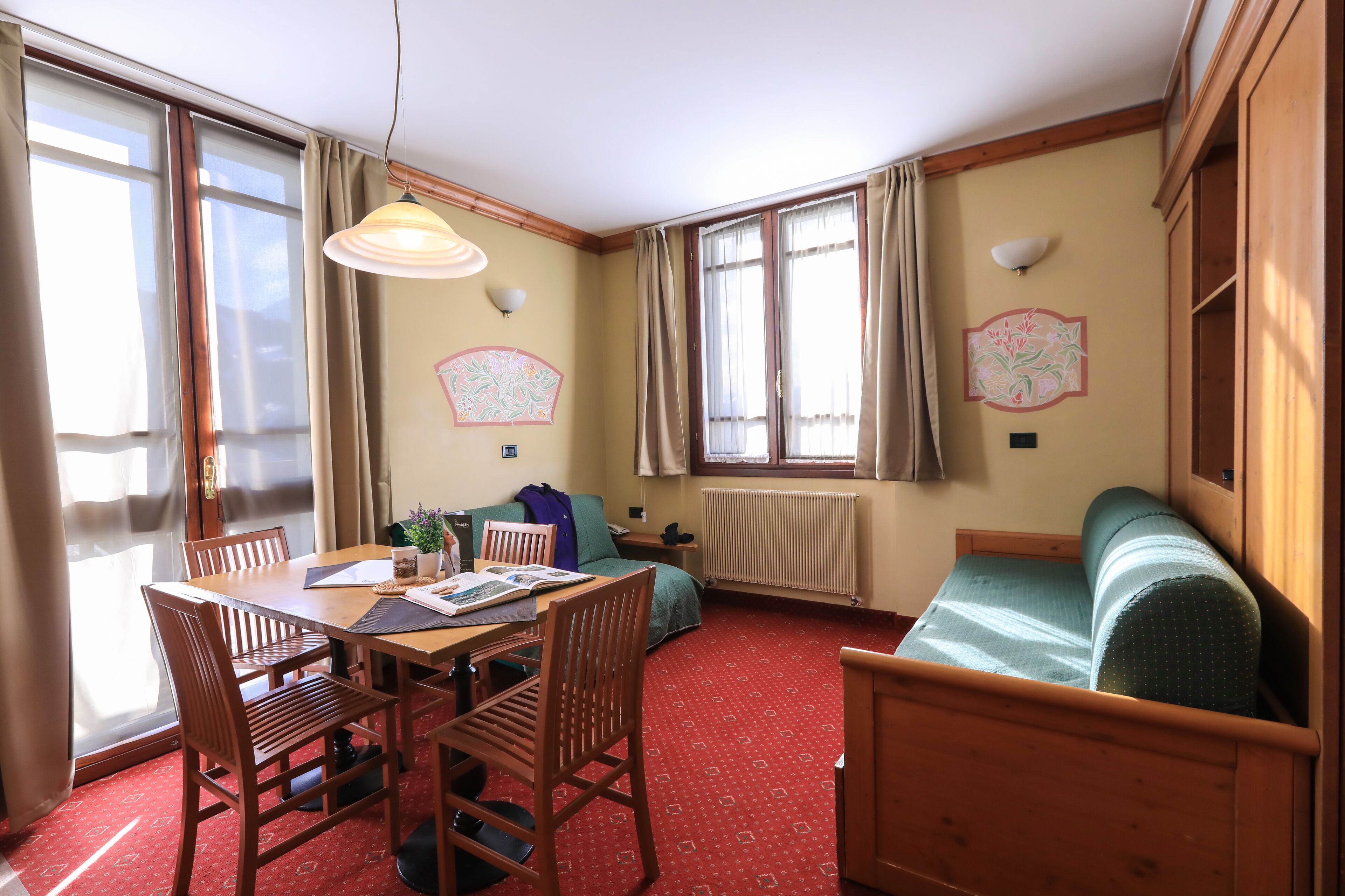 Una habitación con una mesa de madera, sillas, un sofá y una cama.