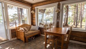 A cozy cabin interior with a wooden bench, a wooden table, and chairs. - Villa Helga (Kemiönsaari)