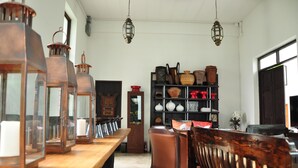 A room with a wooden table, chairs, and a bookshelf filled with various decorative items. - BAAN 88 Chiang Mai (Mae Rim)