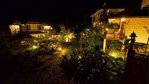 A nighttime view of a resort with multiple buildings, illuminated pathways, and lush greenery. - Pai Vieng Fah (Pai)