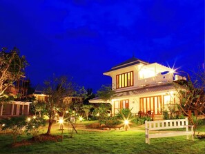 A two-story house with a well-lit front porch and a bench in the front yard. - Pai Vieng Fah (Pai)