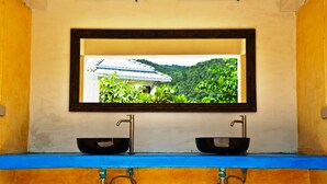 A bathroom with a window above a sink and mirror. - Pai Vieng Fah (Pai)