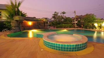 Alberca al aire libre y camastros