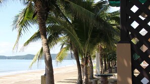 Une plage bordée de palmiers et délimitée par une clôture en bois.