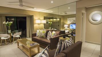 Relax in this stylish living room with a sofa, coffee table, side table, and dining area.