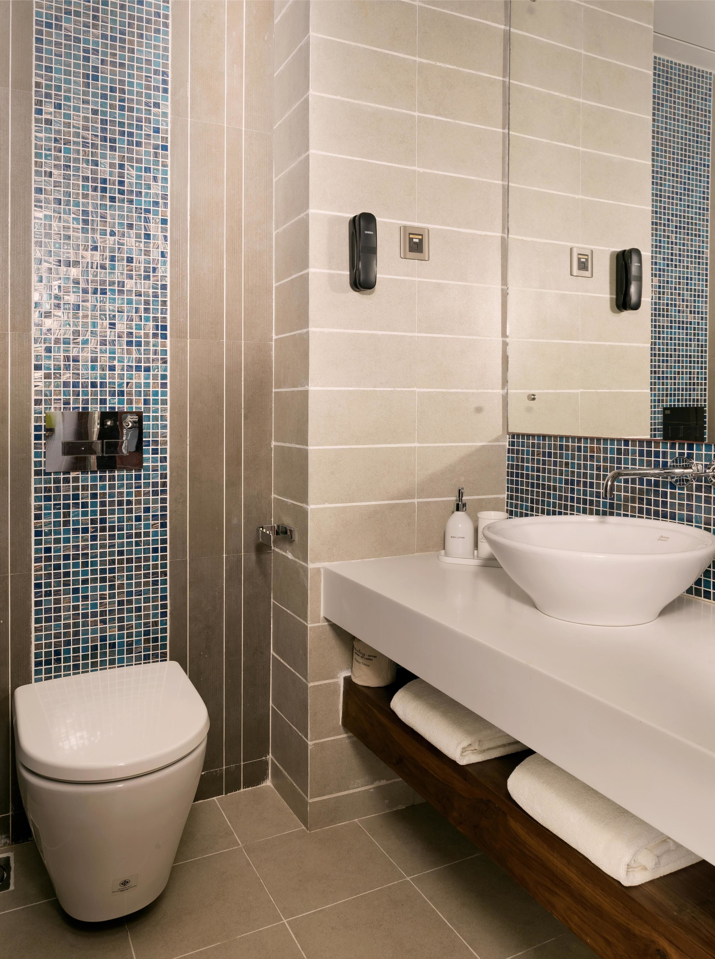 Une salle de bain moderne avec des toilettes, un lavabo et un miroir.