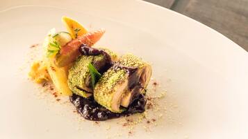 A plated dish with a variety of vegetables and a piece of meat, possibly chicken, garnished with herbs and spices.