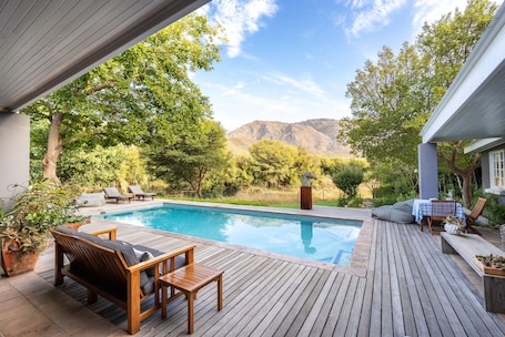 Una piscina al aire libre, sillones reclinables de piscina