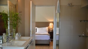 A hotel bathroom with a double sink, a mirror, and a shower area. - In Abundance Guest House (Montagu)