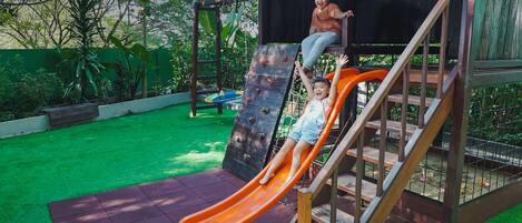 Une aire de jeux avec un toboggan et une structure d’escalade.