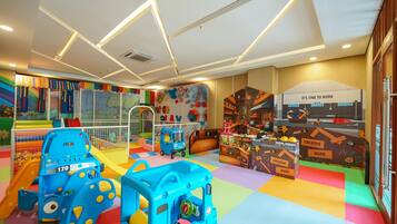 Uma área de recreação infantil com estruturas coloridas, um escorrega e uma casinha.