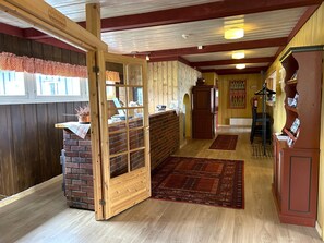 Un'accogliente interno con una reception in legno, un camino in mattoni e un tappeto rosso che conduce a una scala.