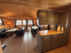 A cozy cabin-style interior with a dining area, kitchen, and seating space. - Torsetlia Fjellstue og Hyttegrend (Nore og Uvdal)