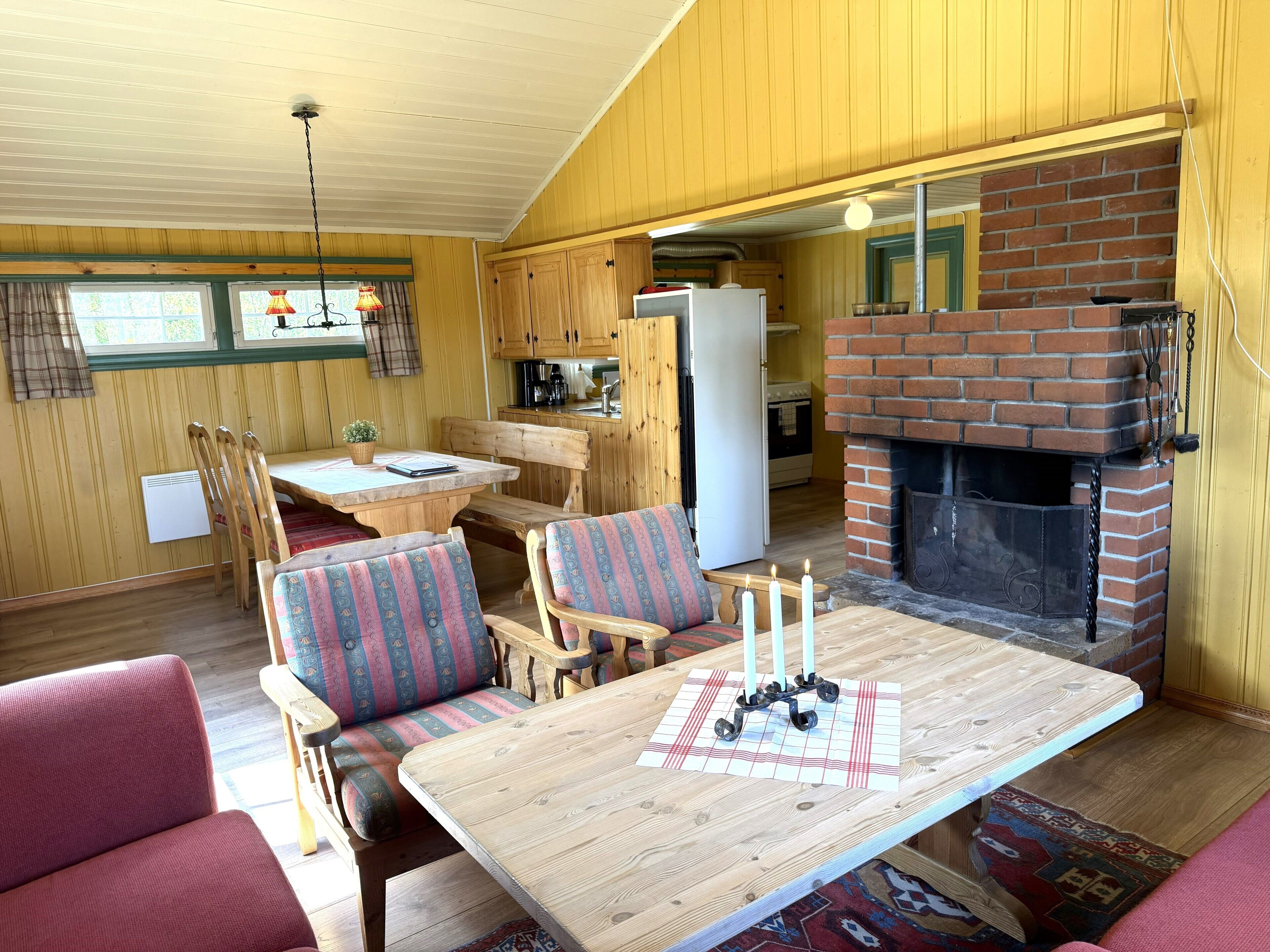 A cozy interior with a dining area, seating, and a fireplace.