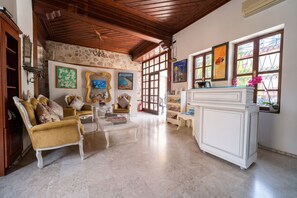 Amplia sala de estar con techo alto, paredes de piedra y ventanas grandes.