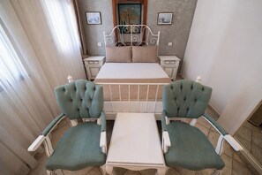 A bedroom with a bed, two chairs, a nightstand, and a small table. - La Paloma Hotel (Antalya)