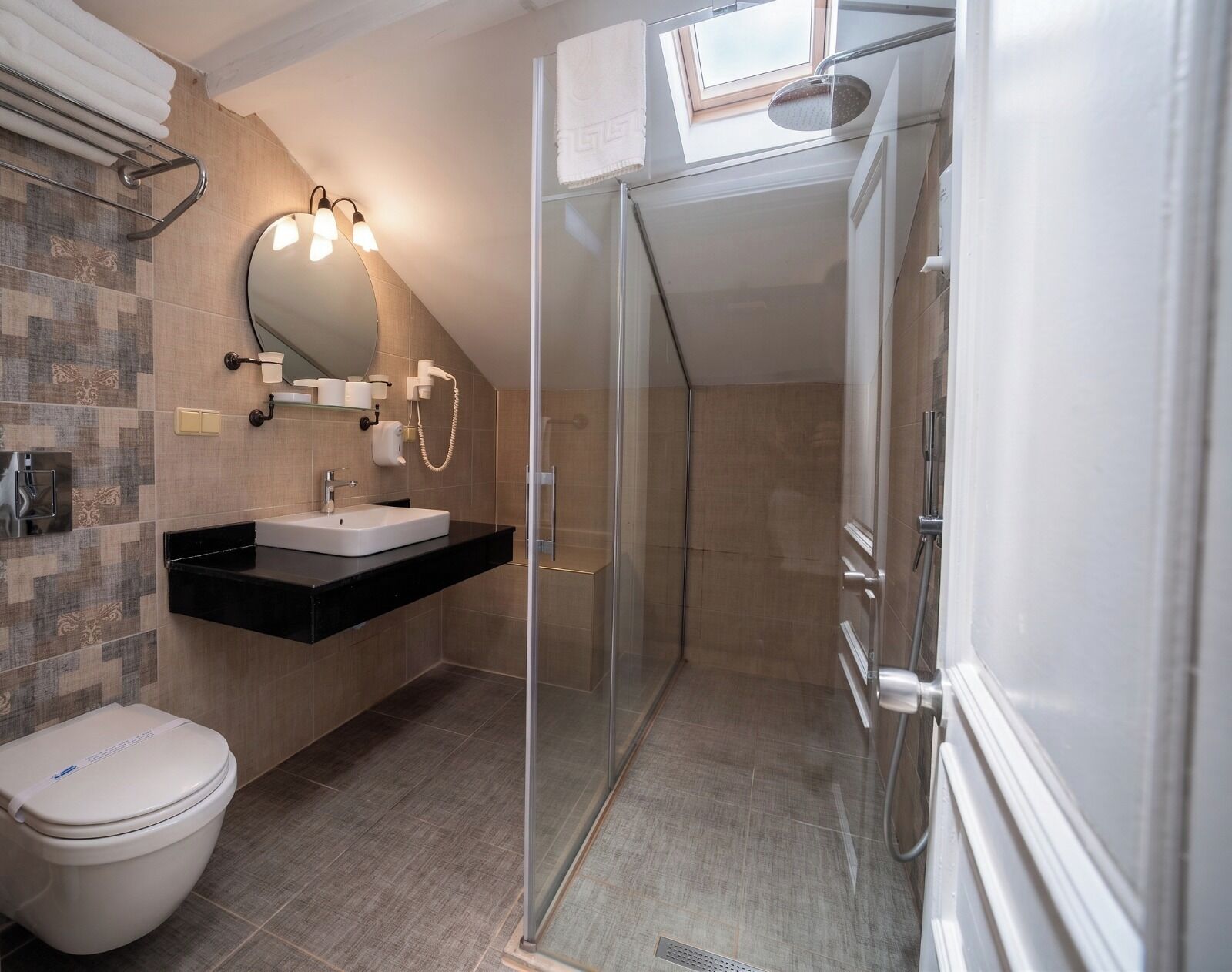 A modern bathroom with a shower, toilet, and a vanity with a mirror.