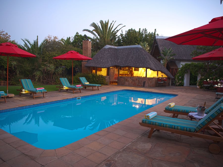 Een buitenzwembad, ligstoelen bij het zwembad