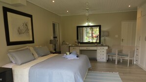 A bedroom with a bed, a desk, a chair, a dresser, and a mirror. - Easy Five (Cape Town)