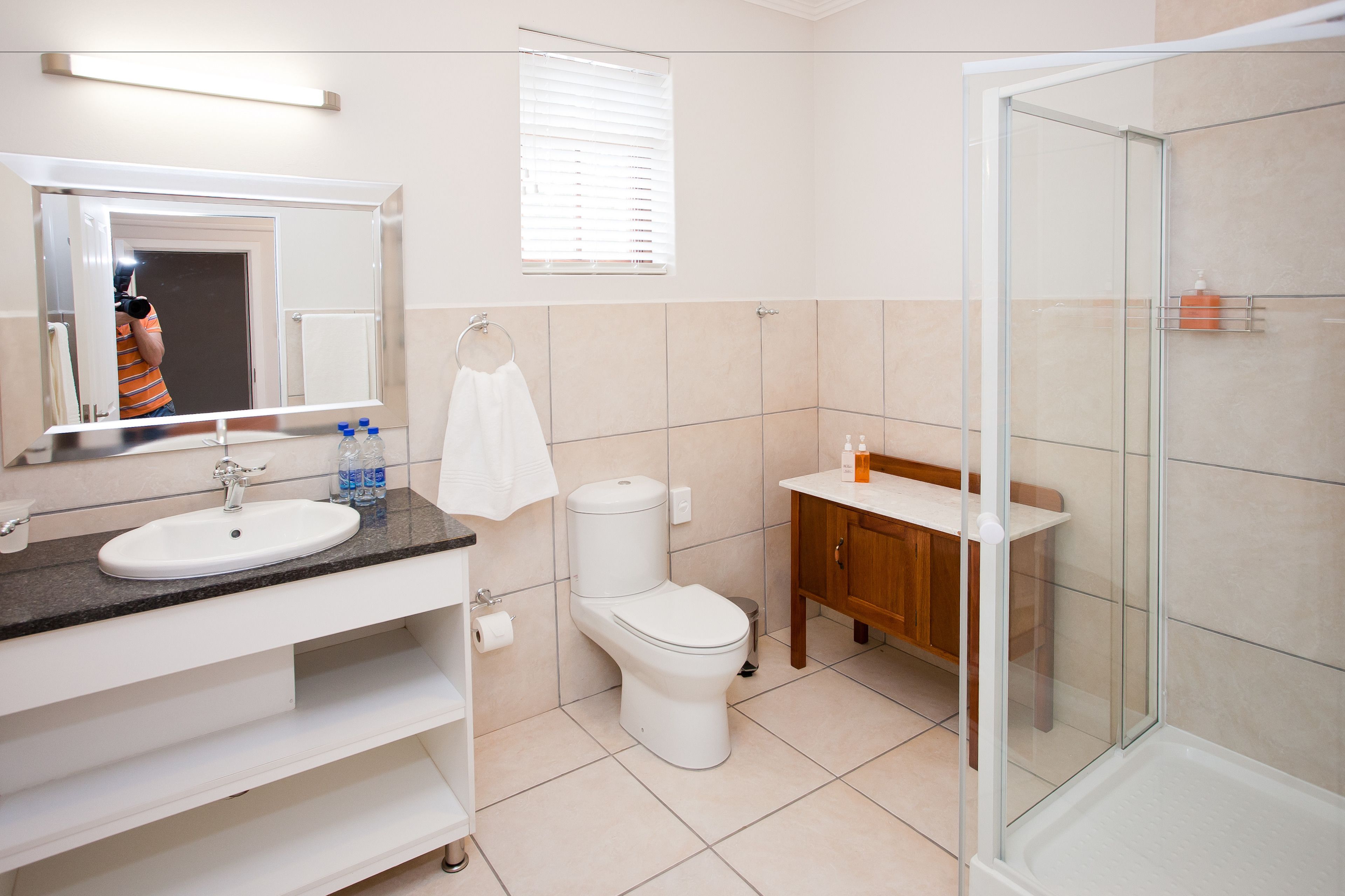 Une salle de bain moderne équipée d’un lavabo, de toilettes et d’une douche.