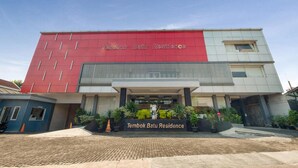 A modern building with a red and white facade, labeled "Tembok Batu Residence." - Tembok Batu Residence (Pogung Lor)