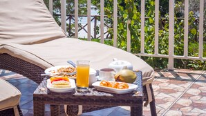 Balcón con mesa listo para el desayuno, con vista a la playa.
