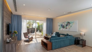 A modern living room with a sofa, a coffee table, a TV, and a dining area with a table and chairs. - Simaisma, A Murwab Resort (Simaisma)