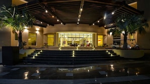 A hotel entrance with a covered outdoor area, steps leading up to the entrance, and palm trees. - Simaisma, A Murwab Resort (Simaisma)