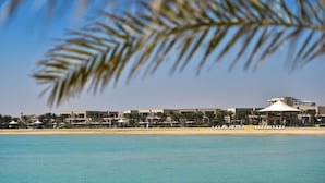 A beachfront hotel with a pool, beach umbrellas, and a large building with a white roof. - Simaisma, A Murwab Resort (Simaisma)