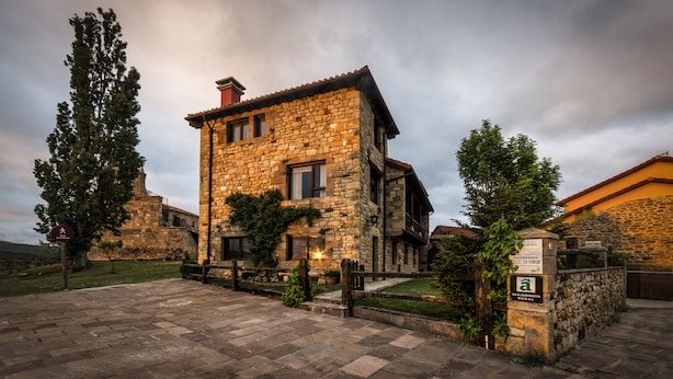 A stone building with a traditional design, featuring a courtyard and a sign indicating a restaurant. - CTR La Coruja del Ebro (Valderredible)