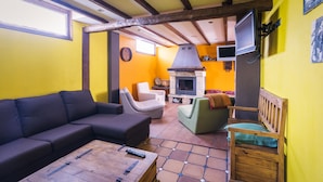 A cozy living room with a sofa, armchairs, a coffee table, and a fireplace. - CTR La Coruja del Ebro (Valderredible)