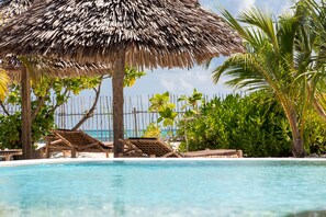 Piscina a l'aire lliure, para-sols i gandules