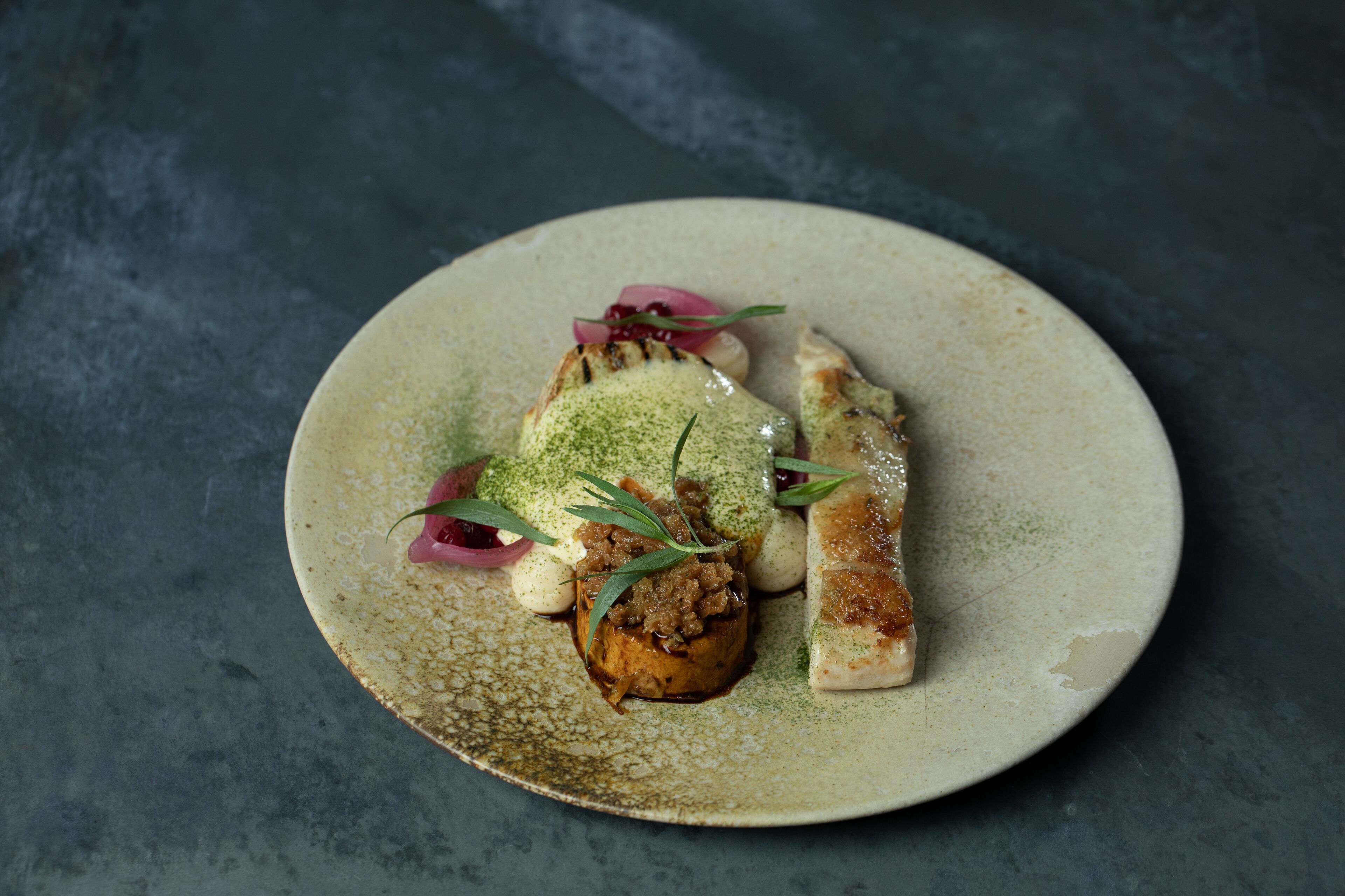 A plate with food items on a textured surface.