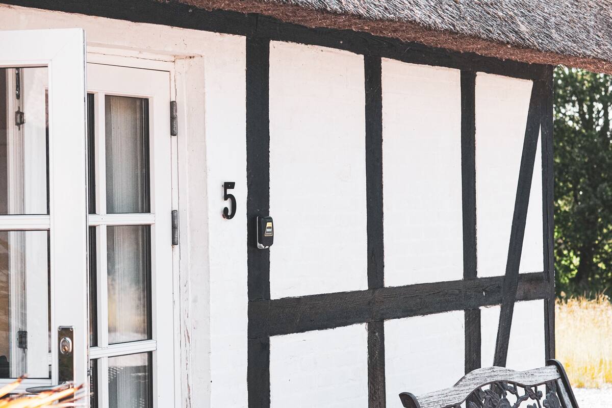 A half-timbered building with a white door and a number '5' on the wall.
