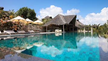 Een buitenzwembad, een infinity pool, parasols voor strand/zwembad