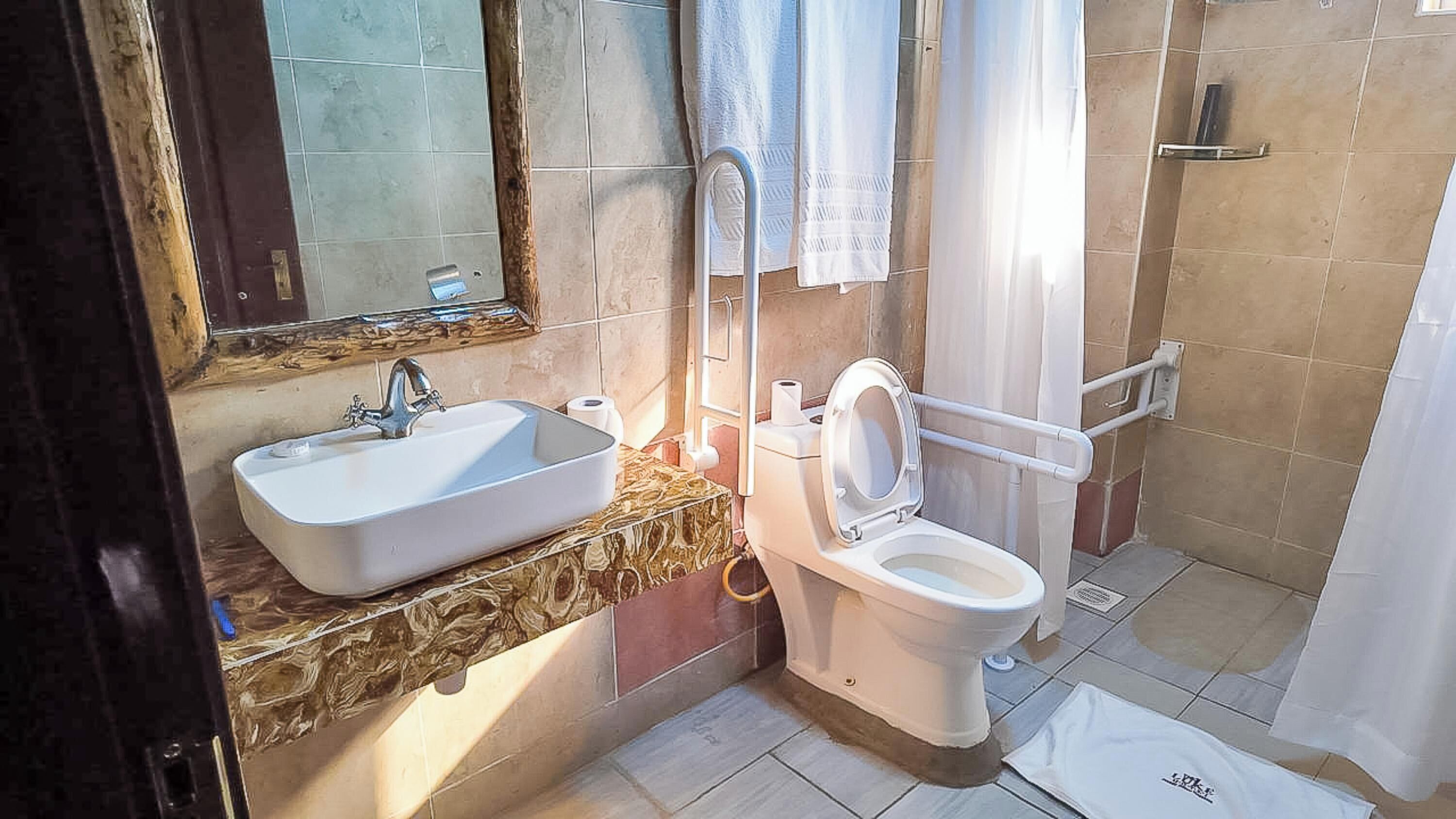 Un baño con lavamanos, inodoro y zona de ducha.