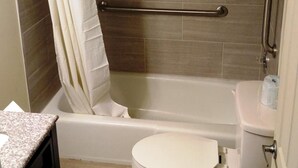A bathroom with a shower, toilet, and a vanity with a countertop.