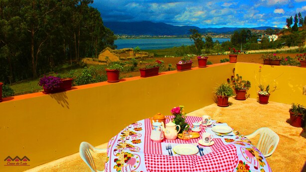 A table set outdoors with a view of a lake and mountains. -  Casa de Huéspedes Casa de Luis (San Pablo del Lago)