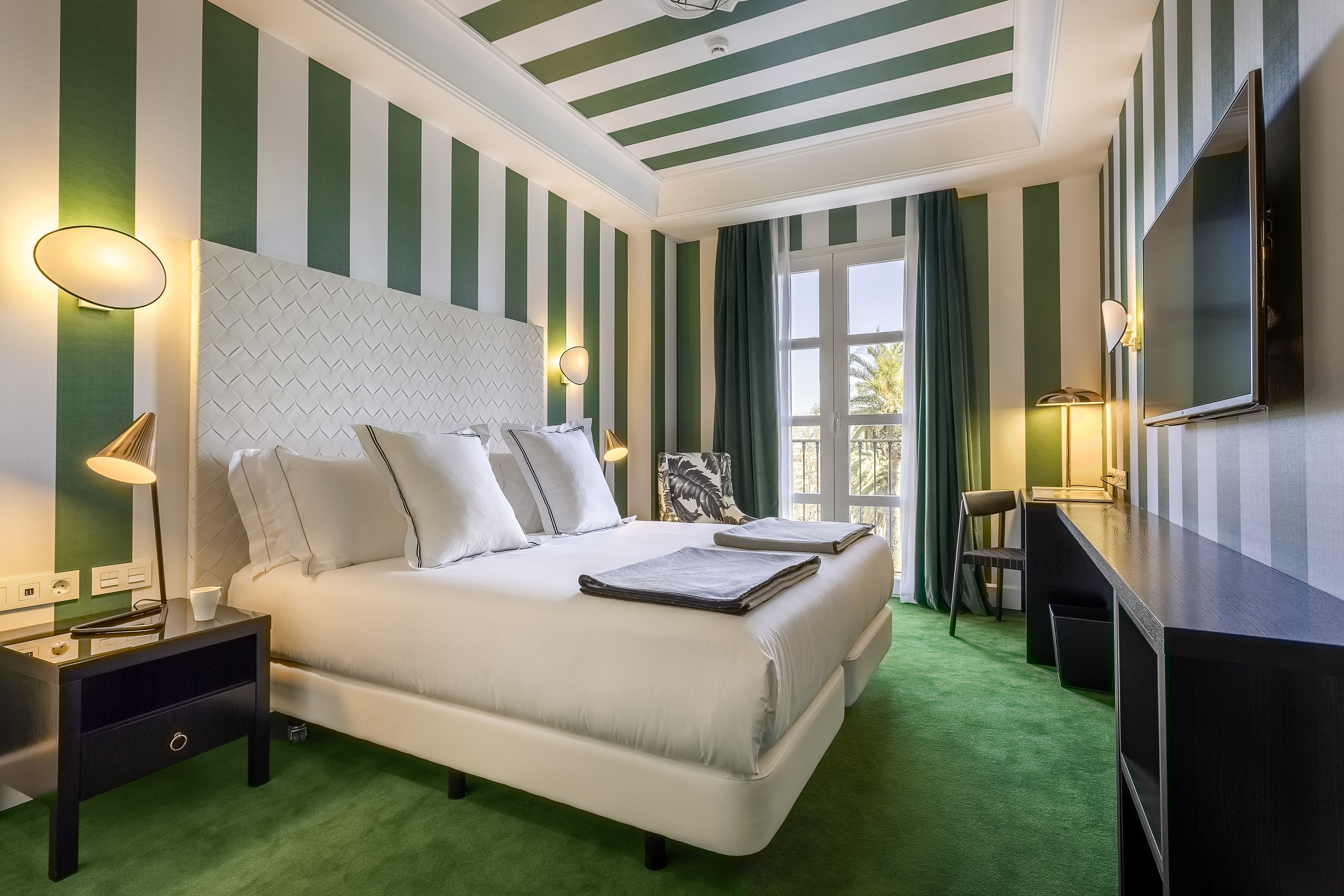 Une chambre d’hôtel avec un grand lit, un bureau et une télévision.