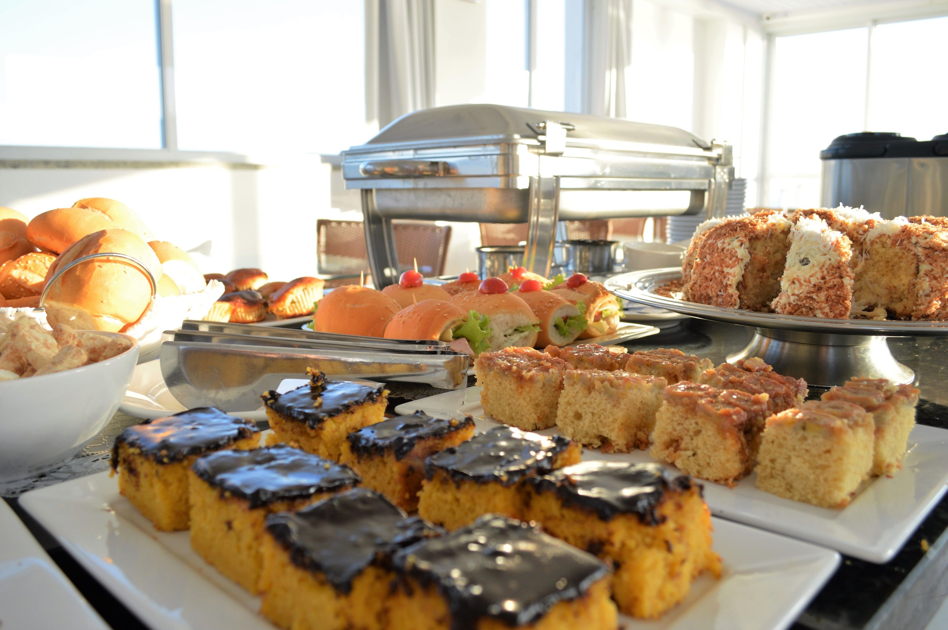 A buffet with various baked goods and sandwiches.