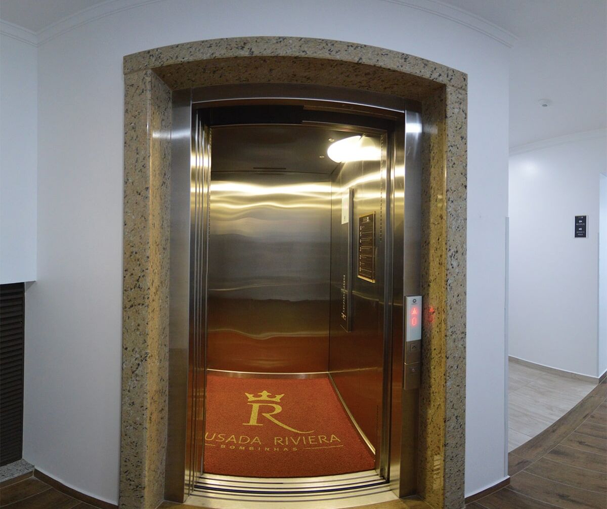 An elevator with a metallic interior and a red carpet with "USADA RIVIERA" text.