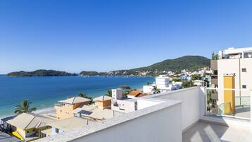 Zona residencial costeira com edifícios virados para o mar, com varandas e vista desobstruída do oceano.