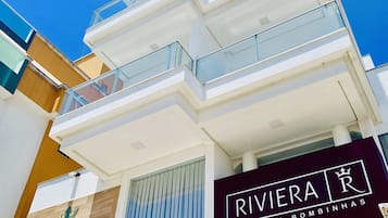 Un immeuble à plusieurs étages dont la façade est ornée d’une grande enseigne indiquant « RIVIERA ».