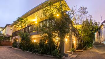 A modern house with a covered porch, a staircase, and a well-maintained garden.