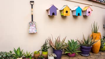 A garden wall with colorful birdhouses and a variety of potted plants.