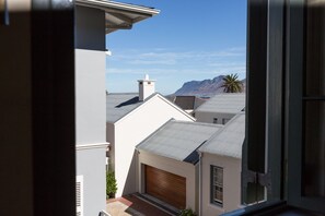 Un quartier résidentiel avec des maisons, un garage et une montagne en arrière-plan.