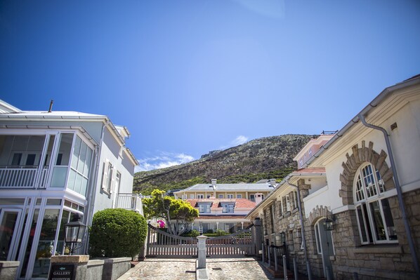 Une vue de rue avec des bâtiments, une porte et une montagne en arrière-plan.