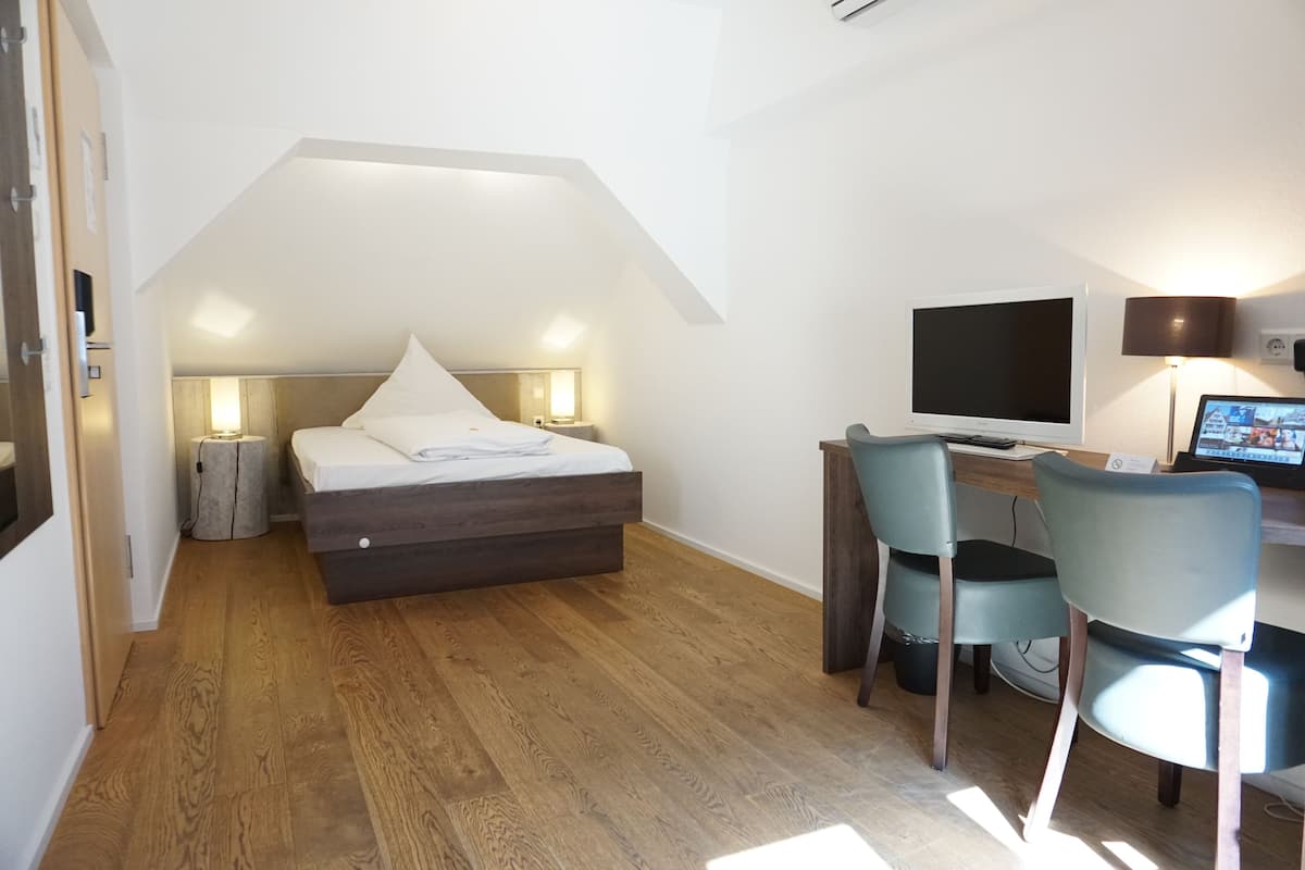 A bedroom with a bed, desk, and computer.