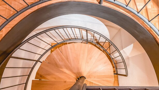 A spiral staircase with metal railings and wooden steps.